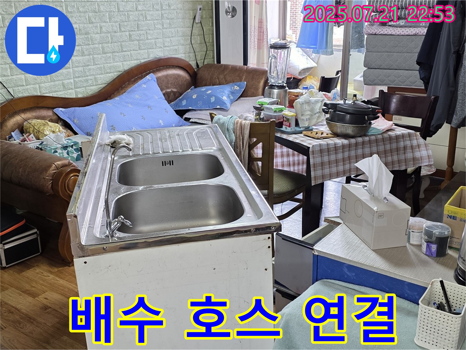 싱크대 주변 정리 후 임시 배수 호스 연결 - 싱크대 주변을 정리하고 임시 배수 호스를 연결하여 물이 잘 빠지도록 했습니다.