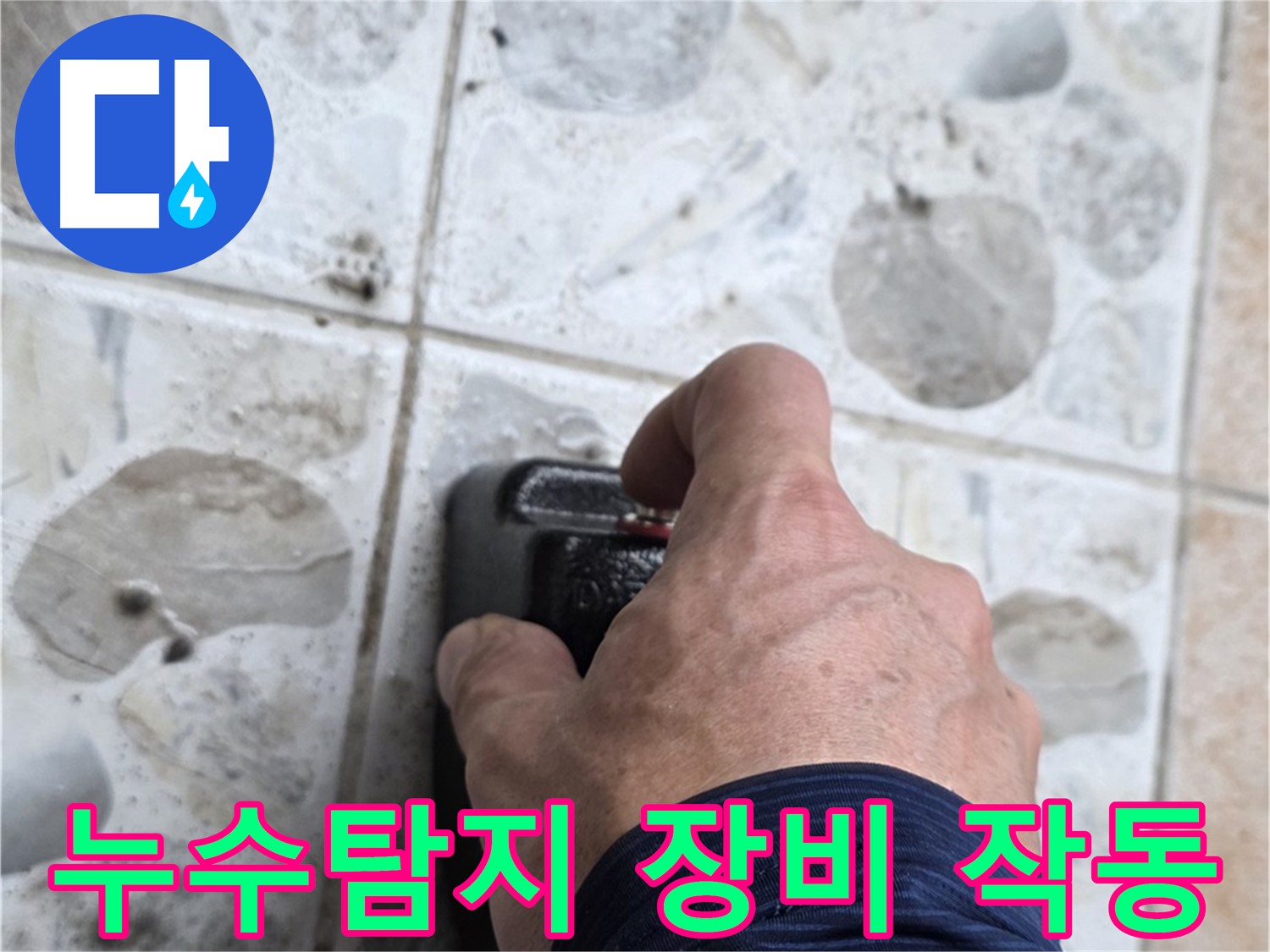 누수 탐지를 위해 전문가가 길음동 숭인로에서 누수 탐지 장비를 작동시키는 모습입니다 - 누수 위치를 정확히 파악하는 중요한 과정입니다.