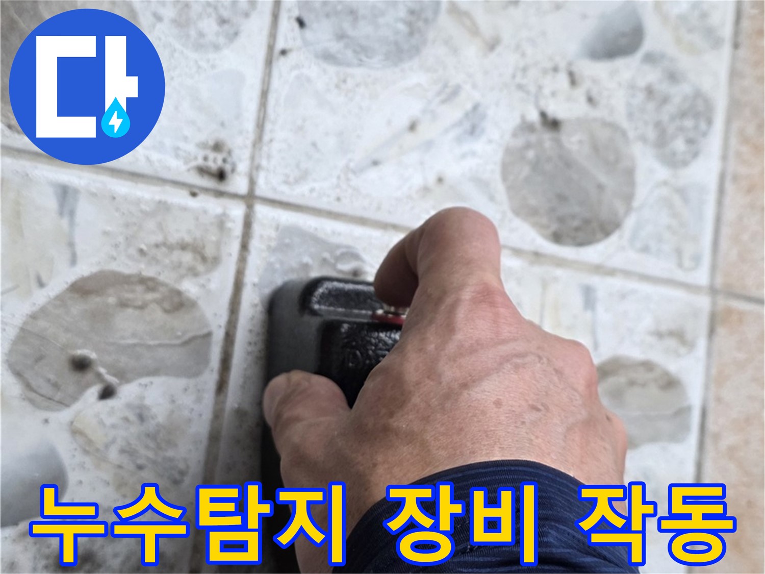 누수 탐지를 위해 전문가가 길음동 숭인로에서 누수 탐지 장비를 작동시키는 모습입니다 - 누수 위치를 정확히 파악하는 중요한 과정입니다.