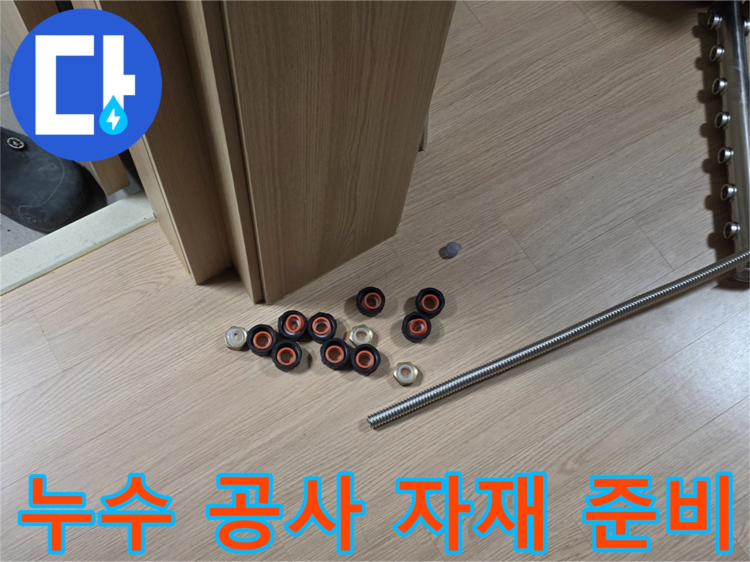 누수 공사를 위한 다양한 자재들이 준비되어 있습니다 - 배관, 연결 부속, 공구 등이 가지런히 놓여 있습니다.