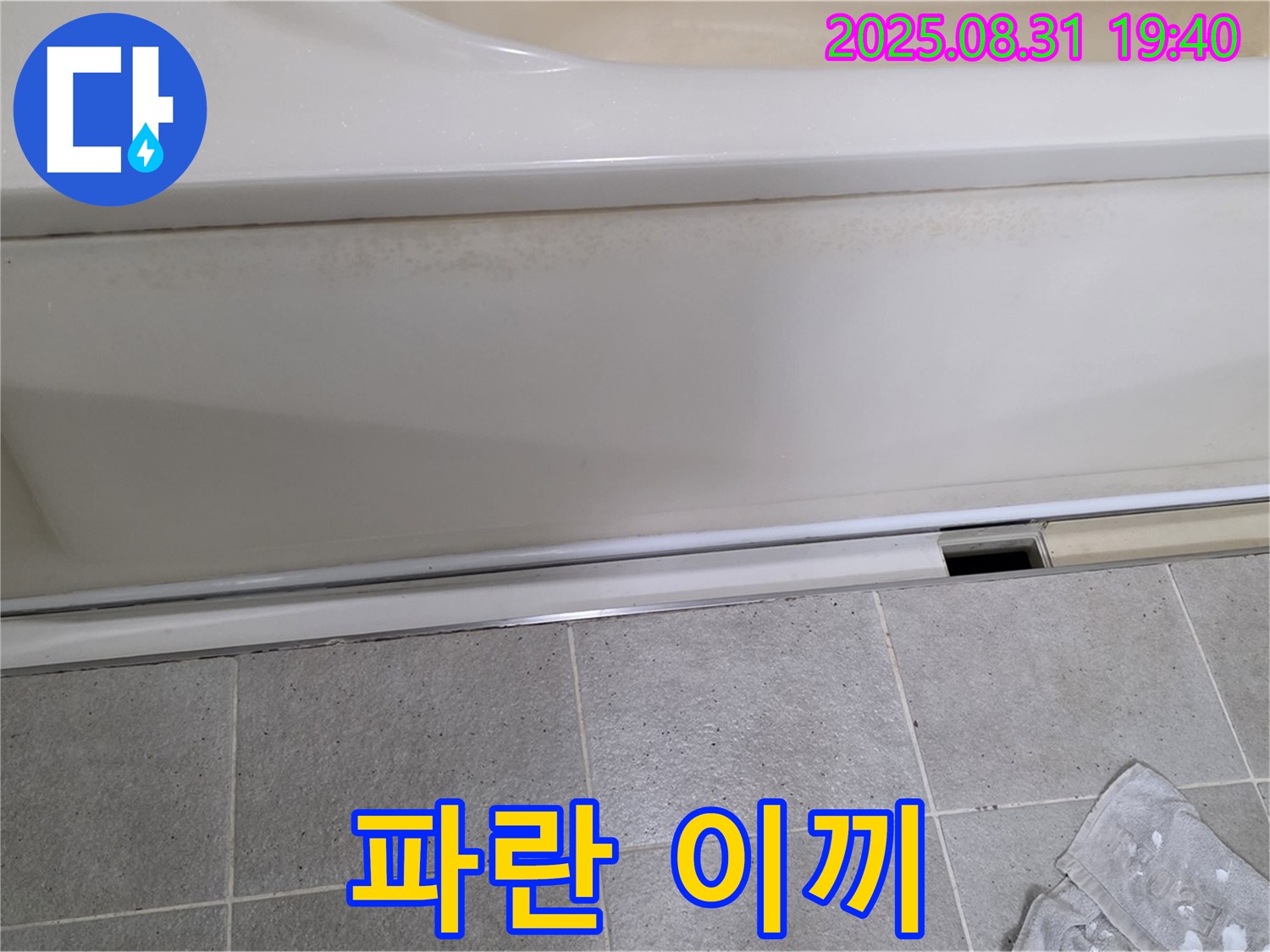 산운마을 욕조 하단 누수 - 패널과 타일 사이 틈새에 물이끼 때문에 파랗게 변색된 상태입니다.