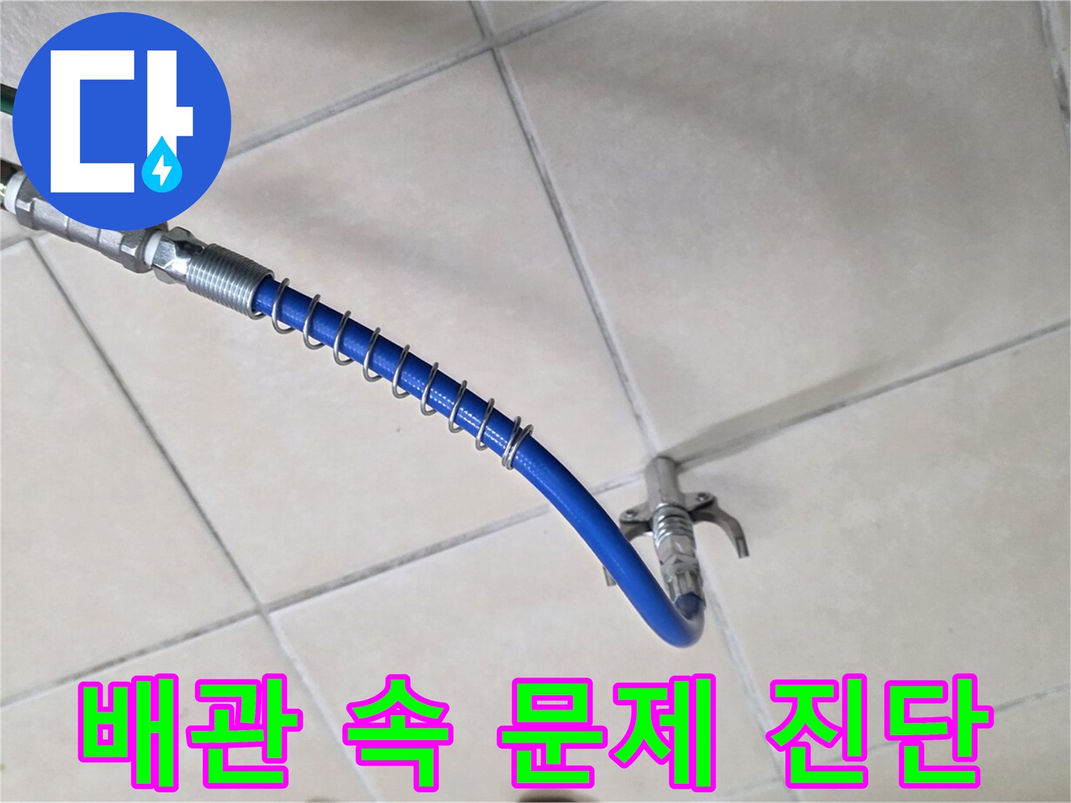 타일 바닥의 파란색 호스와 금속 연결 부품