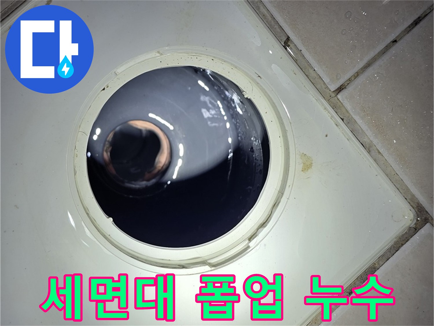 타일 바닥 유가 구멍 사이로 보이는 하수도 배관