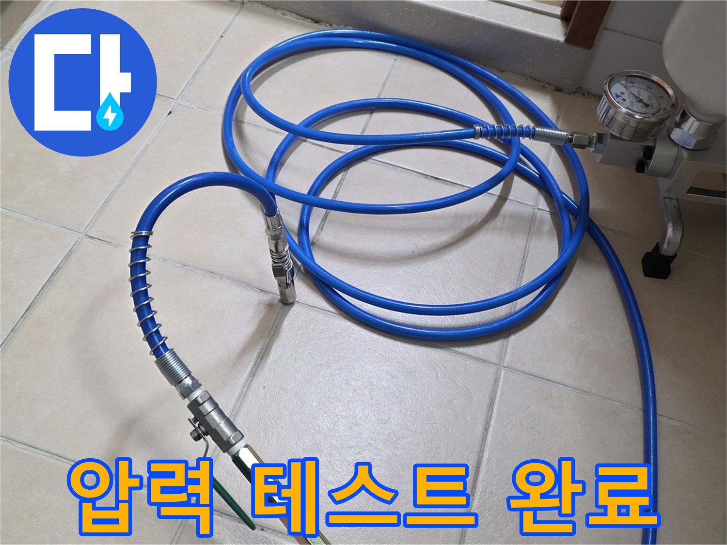 압력 게이지와 연결된 파란색 호스가 바닥에 놓여 있는 모습입니다