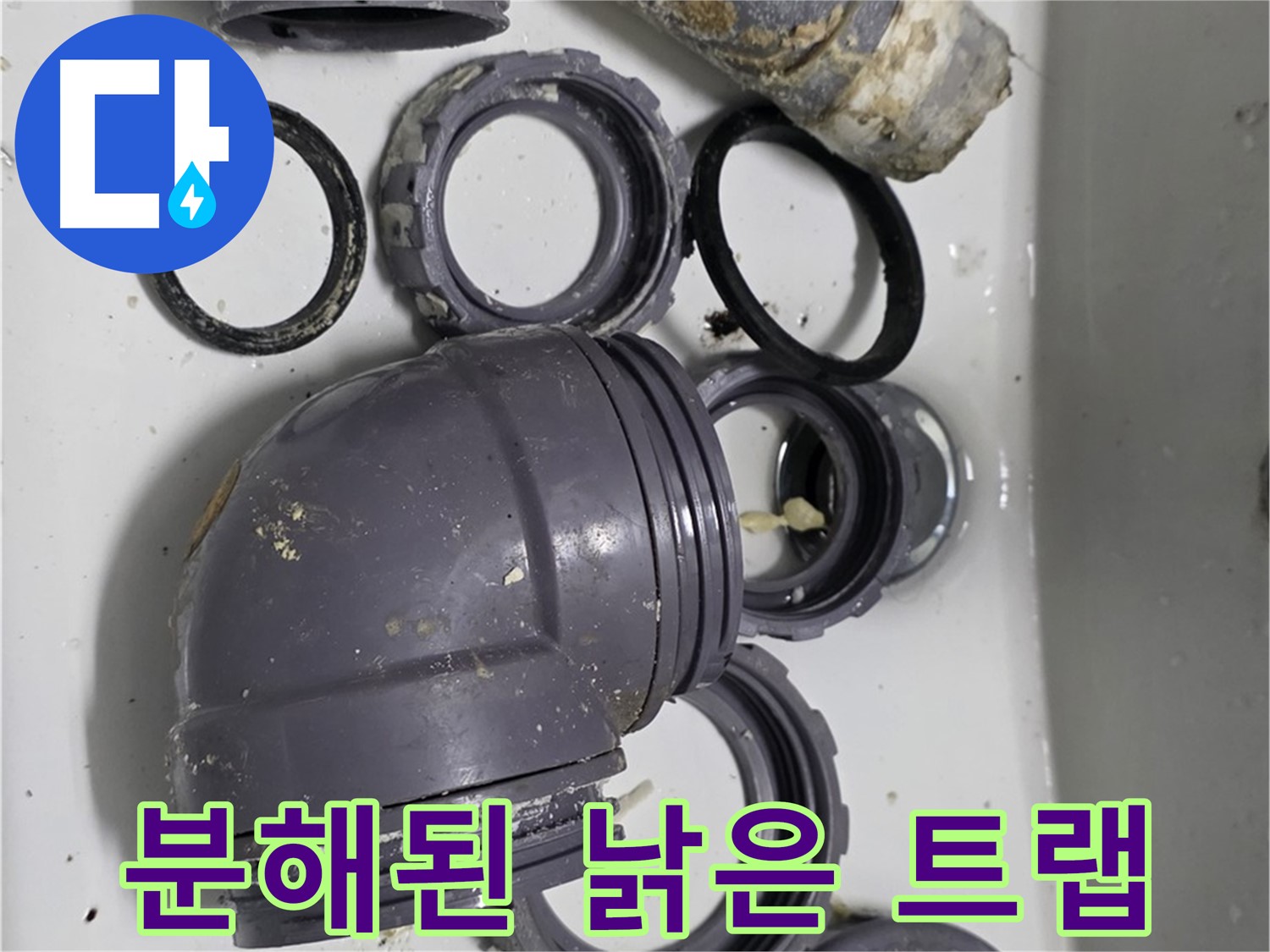 분해된 낡은 트랩 - 낡고 손상된 싱크대 트랩 부품들이 분해되어 있습니다.