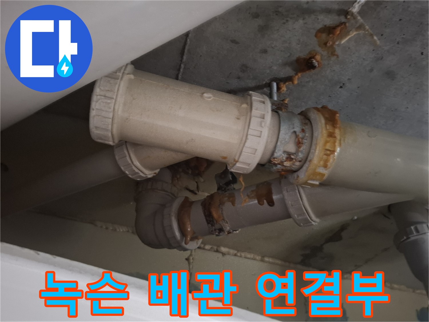 녹슨 배관 연결부 - 심하게 녹슨 배관 연결 부위에서 누수가 진행 중 - 즉시 점검이 필요합니다.