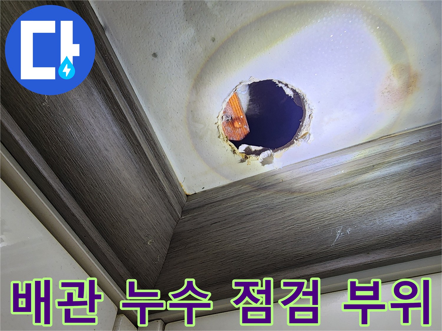 천장 구멍을 통해 보이는 배관과 주변의 젖은 마감재