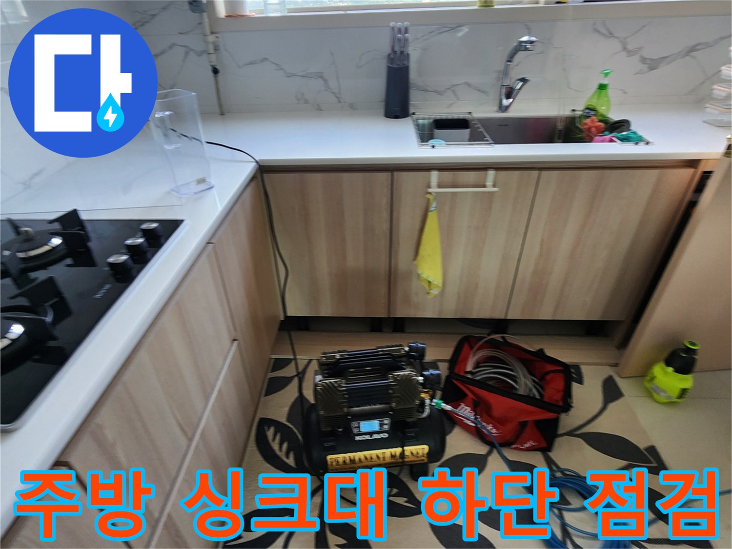 싱크대 아래 공간에 배치된 누수 탐지기와 검사용 호스 세트