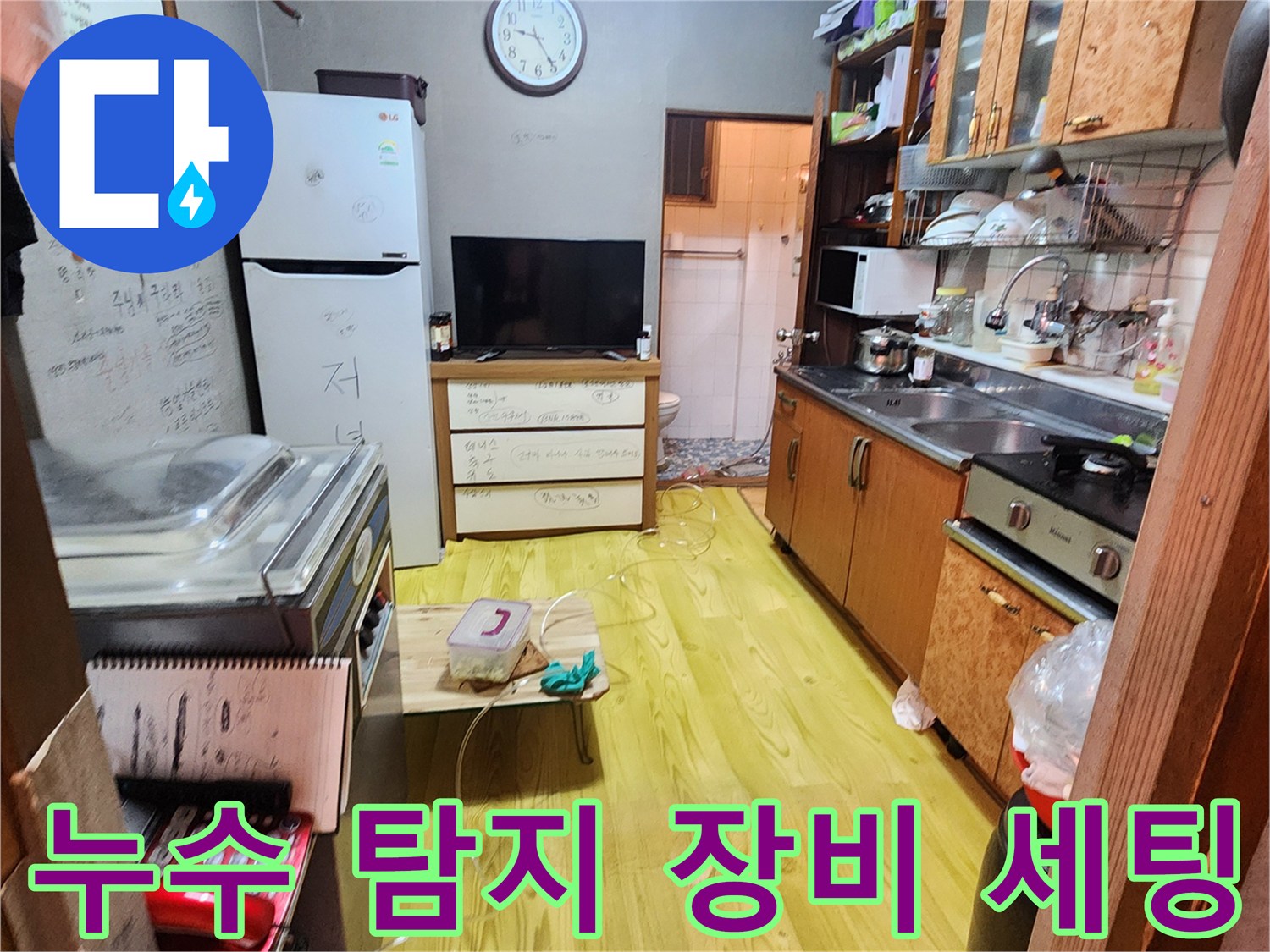 주방 바닥과 싱크대 주변에 배치된 누수 탐지용 호스와 장비들