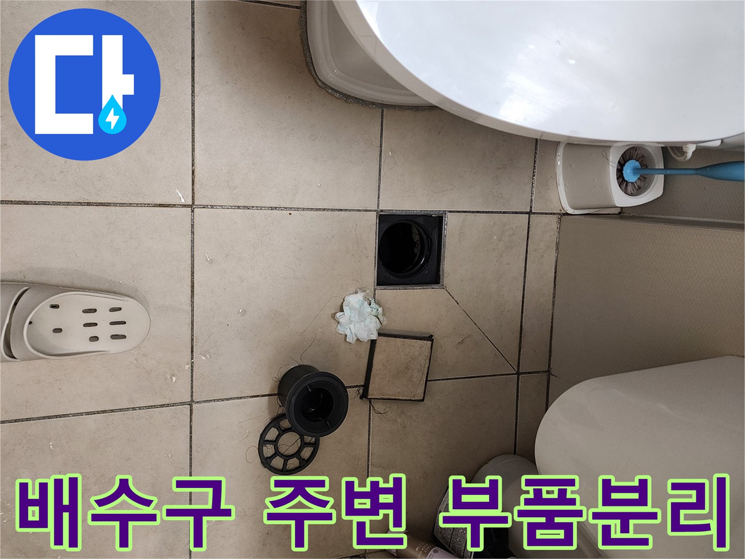 욕실 바닥 배수구 부속과 탈거된 유가 덮개가 놓인 모습