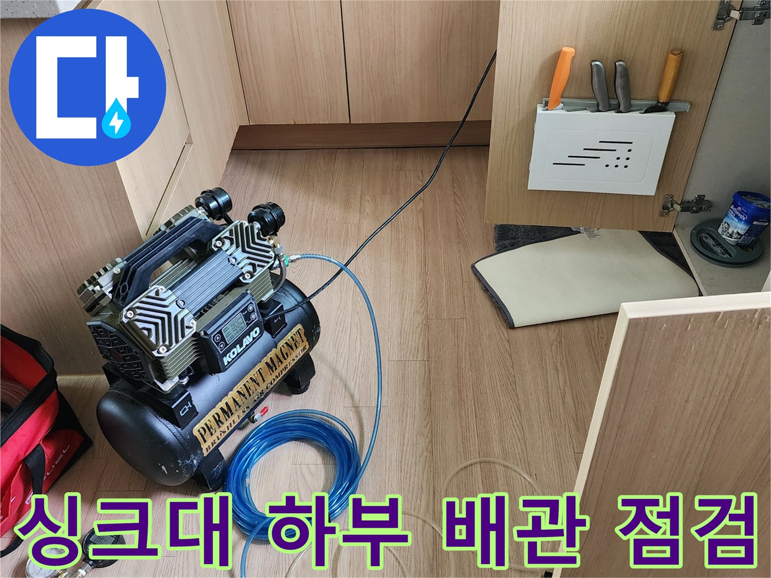 싱크대 아래 공간에 놓인 컴프레서와 압력 게이지 장비