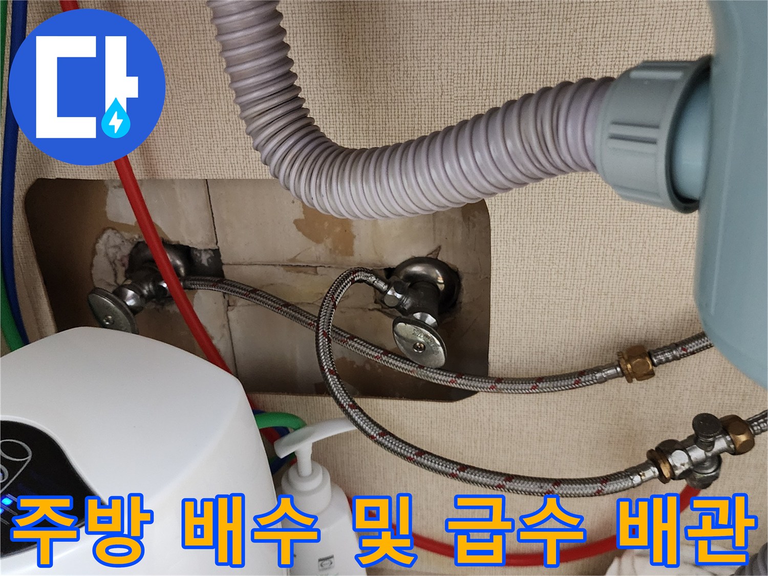 싱크대 하단 벽면 밸브와 주름관 연결 상태를 촬영한 사진입니다.