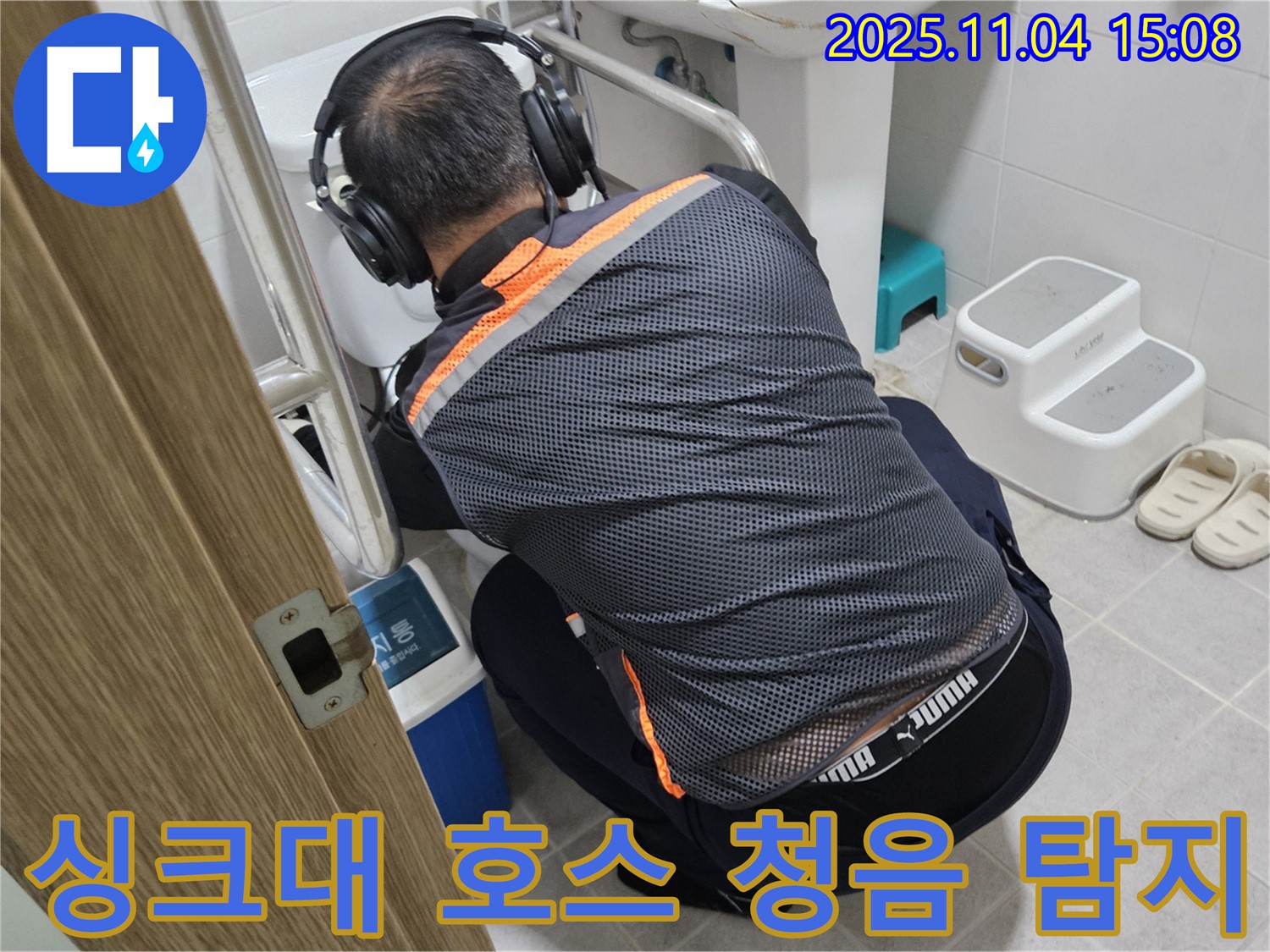 누수 전문가가 싱크대 호스 연결 부위에 청음 탐지 장비를 대고 누수 여부를 확인하고 있습니다 - 꼼꼼한 탐지로 숨은 누수까지 찾아냅니다.