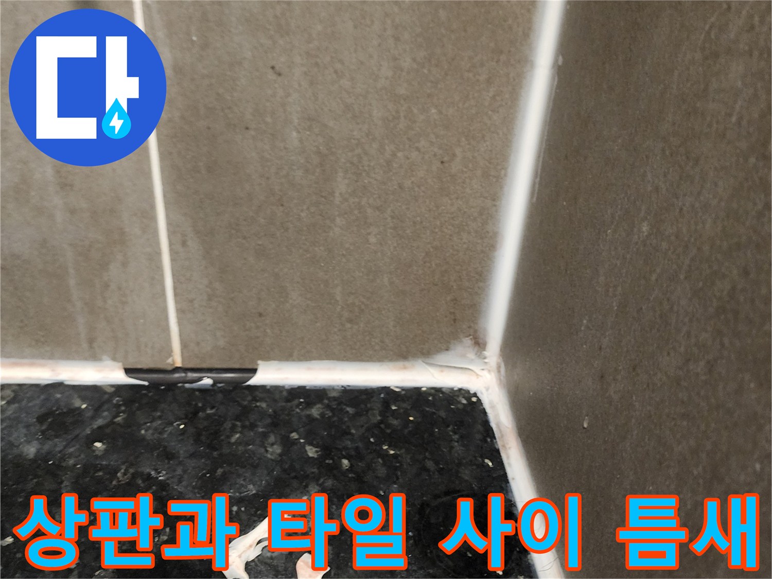 싱크대 하단 검은색 상판과 벽면 타일의 경계 부분 상세 사진