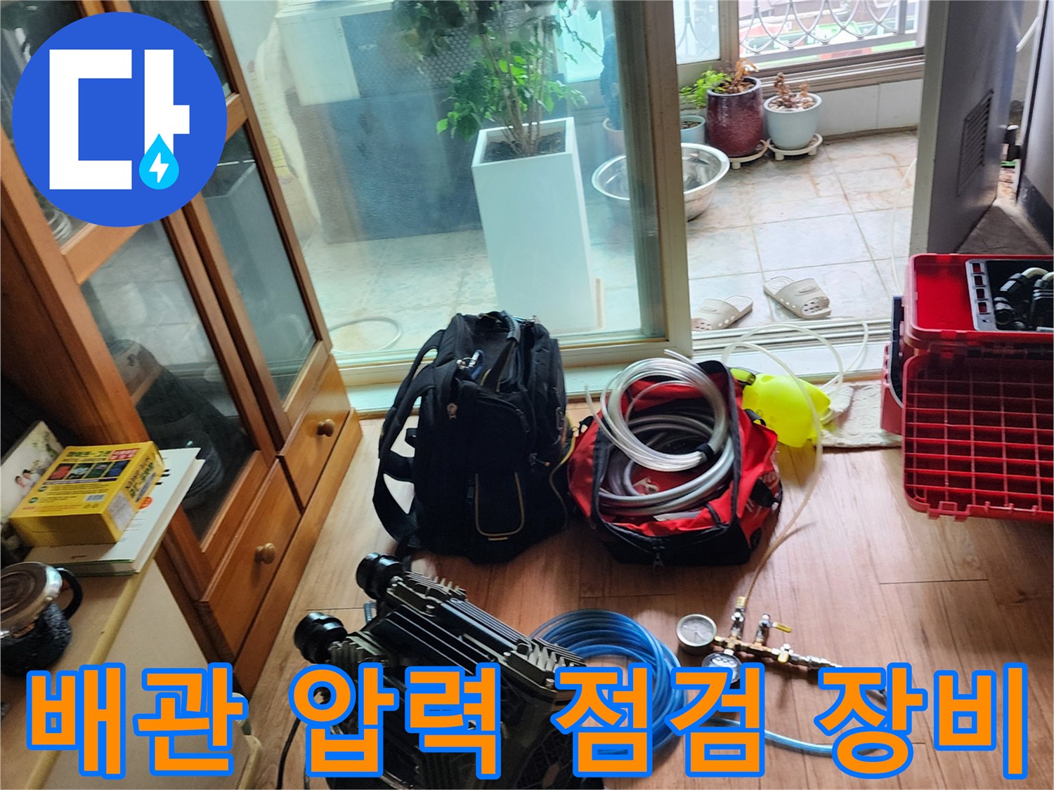누수 진단을 위해 바닥에 준비된 공기 압력계와 호스 및 전문 장비들