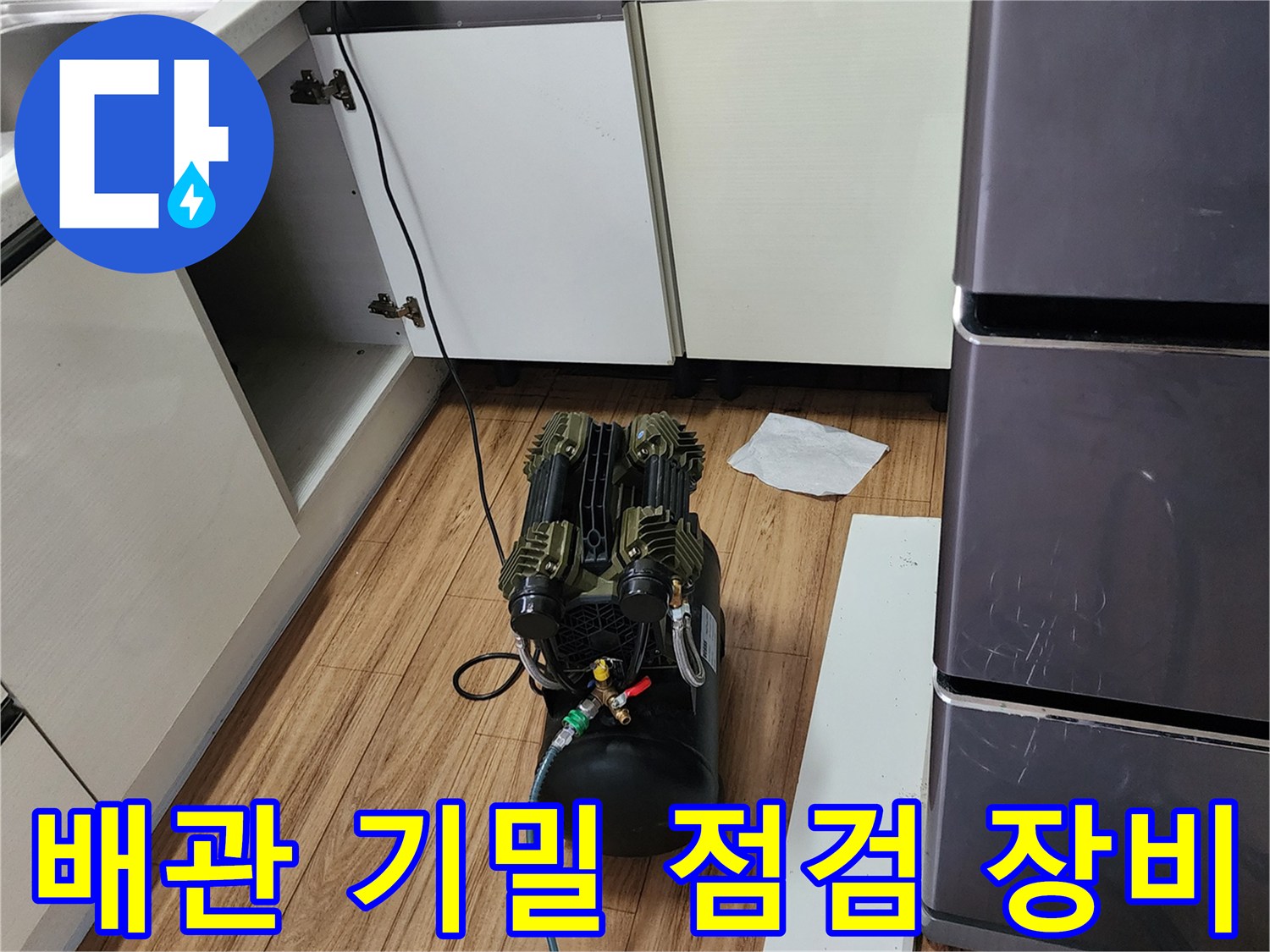 주방 싱크대 하부 공간에서 진행 중인 배관 공압 테스트 과정