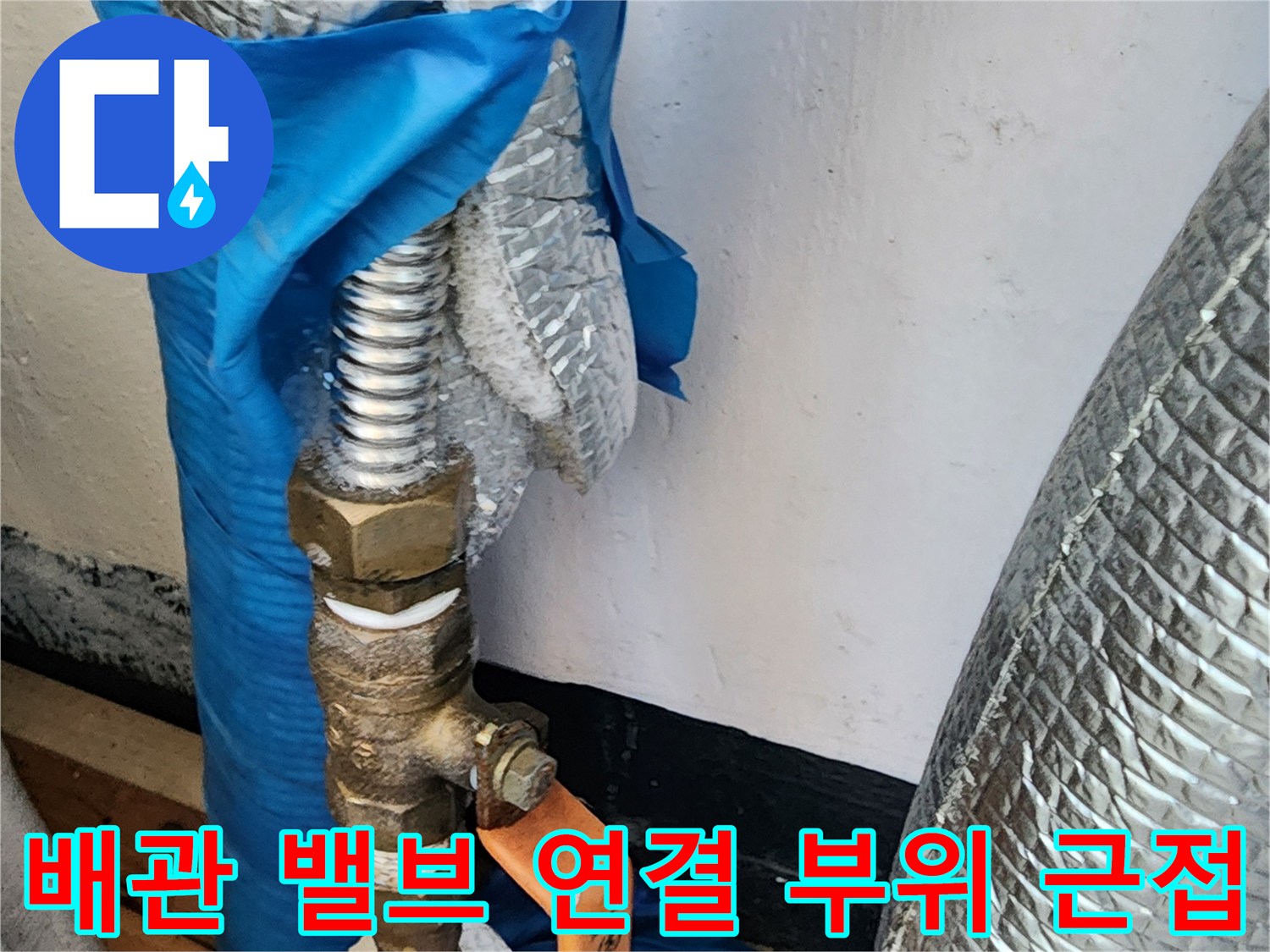 은색 보온재와 파란색 마감재가 있는 배관의 밸브 부분