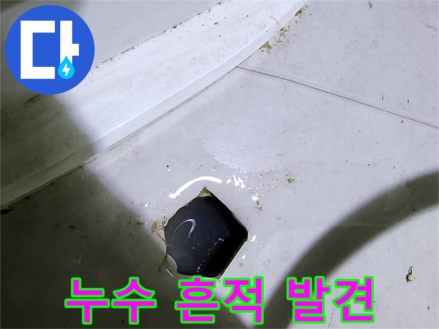 타일 틈새 배관 입구 주변의 물기 및 얼룩 상태를 보여줍니다.