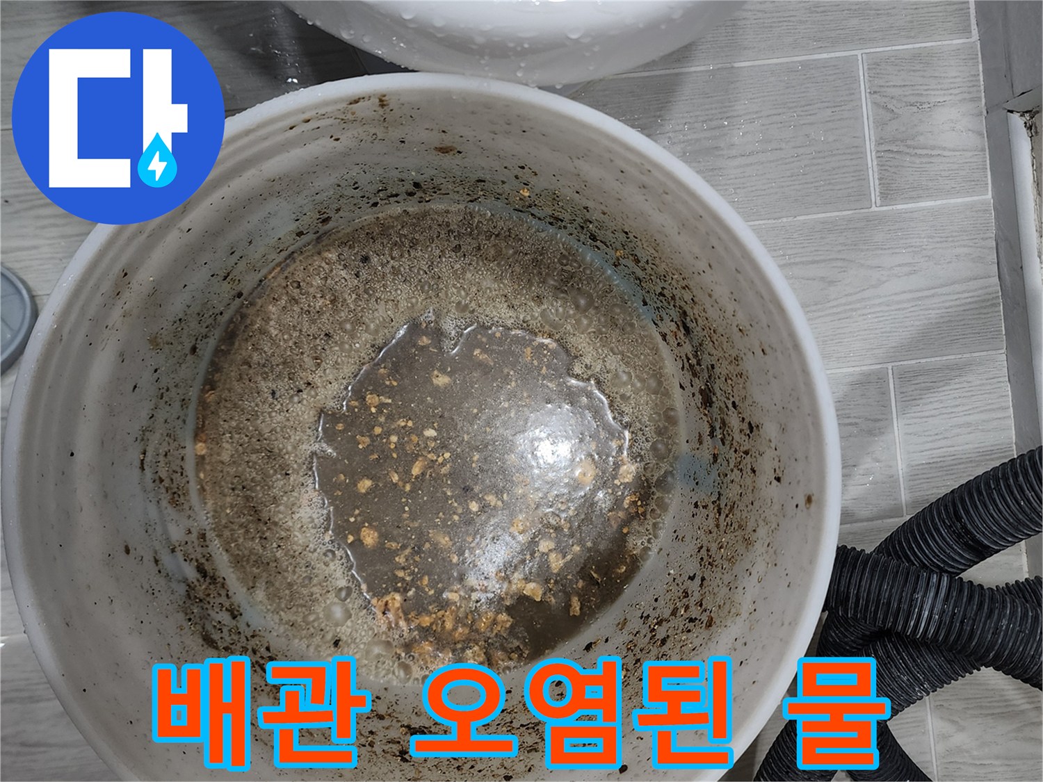 싱크대 하부 배관에서 흘러나온 이물질이 섞인 탁한 물
