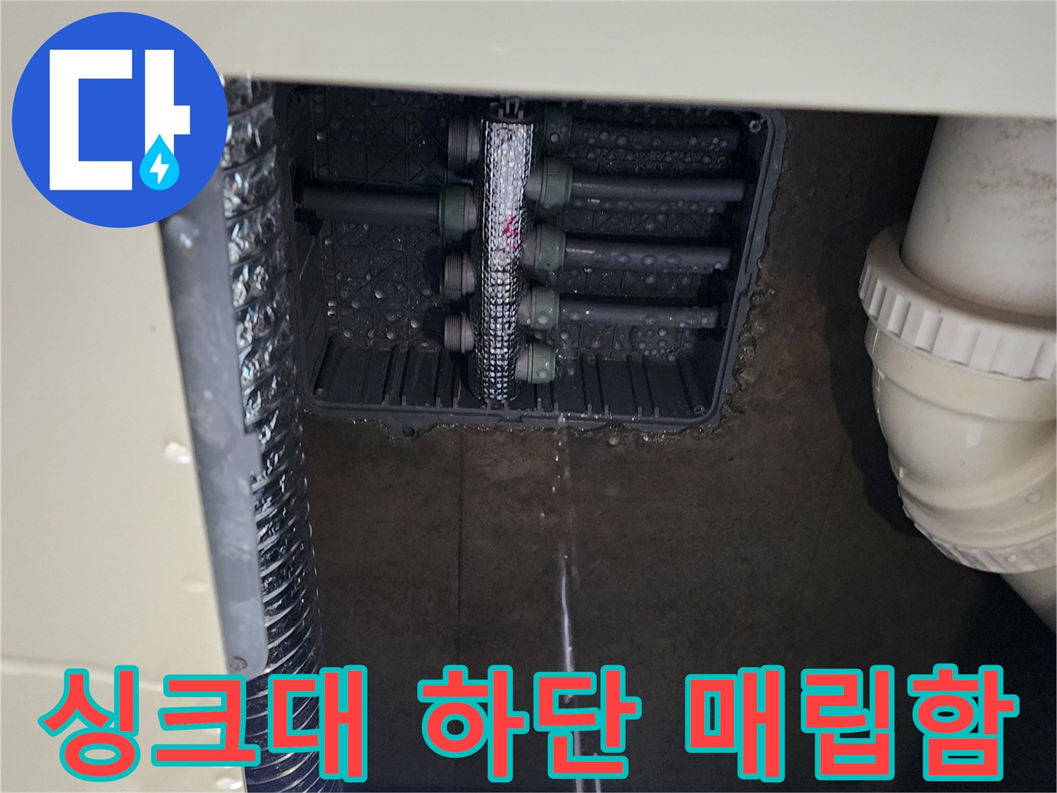 싱크대 하부장 아래 매립된 분배기 주변의 누수 흔적