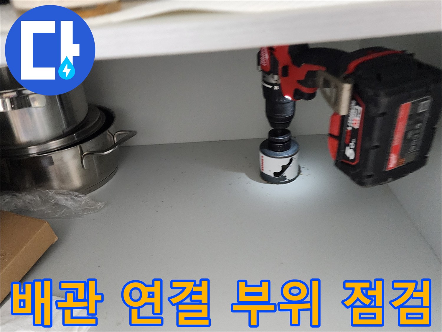 전동 드릴 조명-어두운 싱크대 하부 배관 주위를 비추는 모습