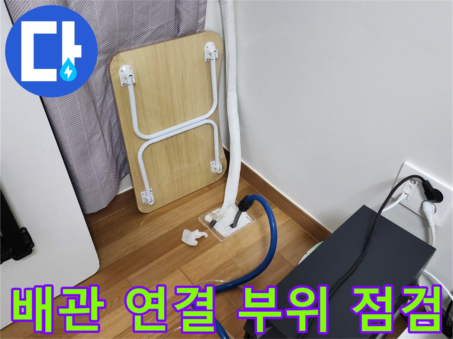 바닥에 설치된 배관 분기점과 압력 테스트를 위한 호스 연결 모습입니다.