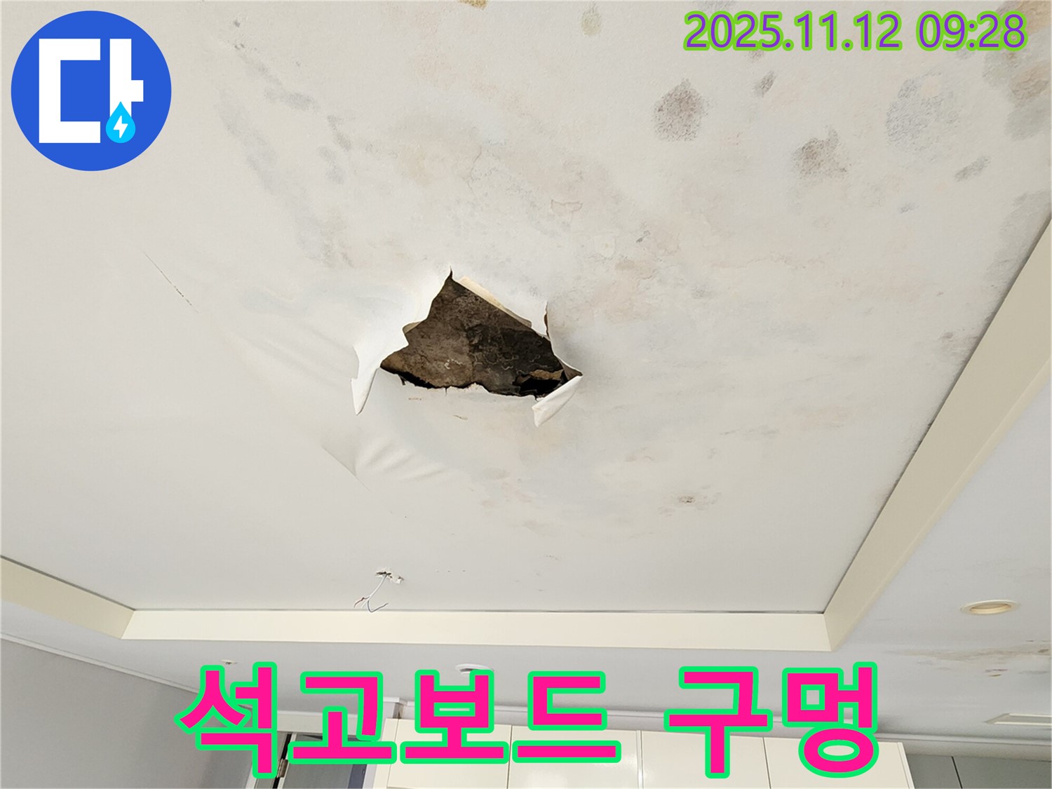 석고보드 구멍 - 누수로 인해 천장 석고보드에 생긴 큰 구멍을 보여줍니다.