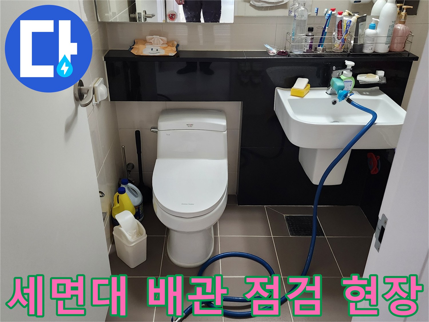 화장실 세면대 하단 수전 부위에 연결된 누수 탐지용 장비와 배관 모습