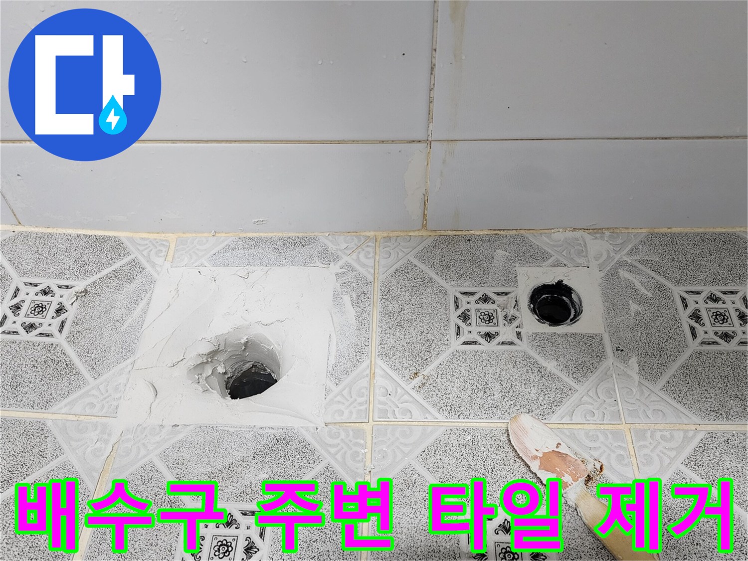 하수구 입구 쪽 타일을 파내어 내부 배관을 드러낸 작업 상태입니다.