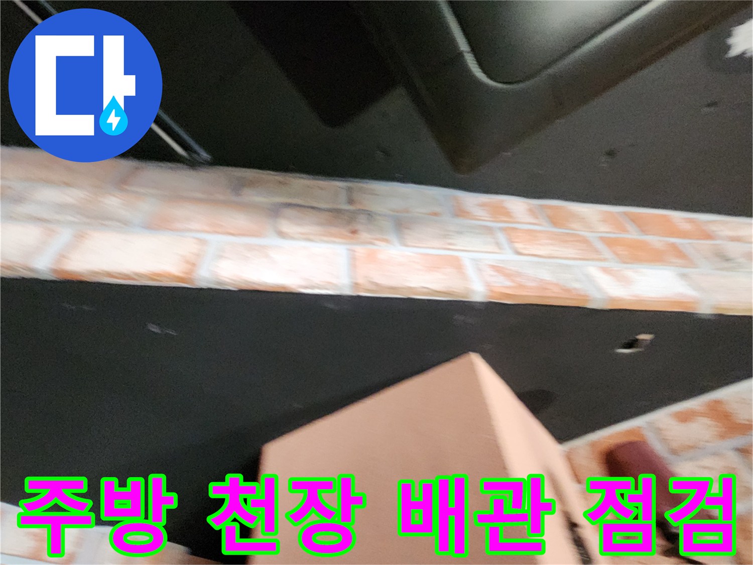 식당 주방의 어두운 천장 구조와 벽면 타일 경계 부위 촬영