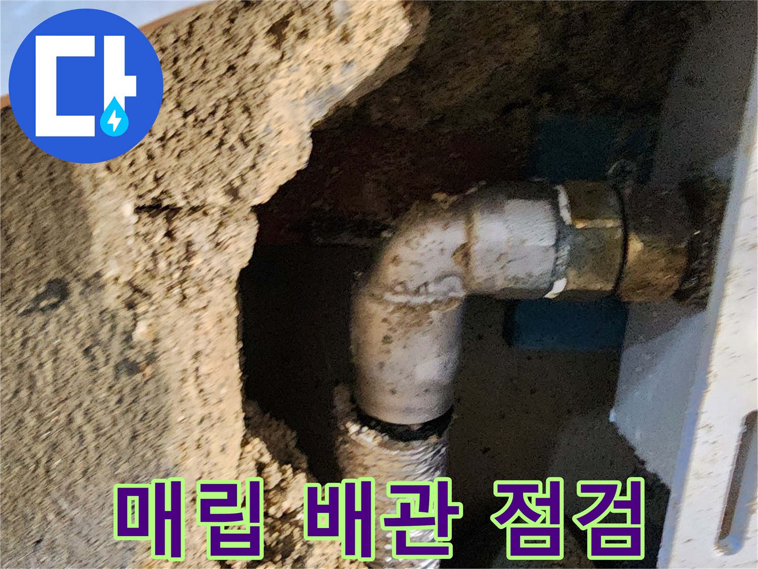 벽을 파쇄하여 드러난 은색 엘보 배관과 연결 부위의 모습입니다.