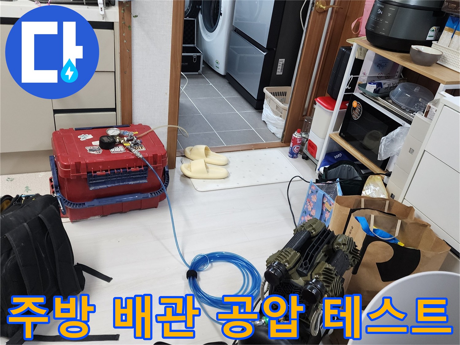 주방 싱크대 하부 배관의 누수 여부를 확인하기 위해 공압 장비를 연결한 모습입니다.