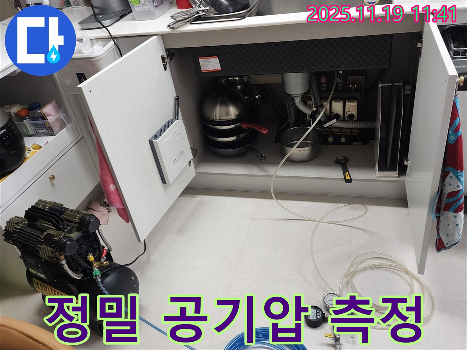 포천 내촌 누수 현장 - 싱크대 하부에서 정밀 공기압 측정 장비를 사용하여 압력을 측정하는 모습입니다.