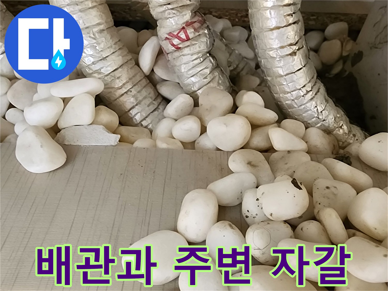 보온재로 감싸진 배관-주변의 하얀 자갈층