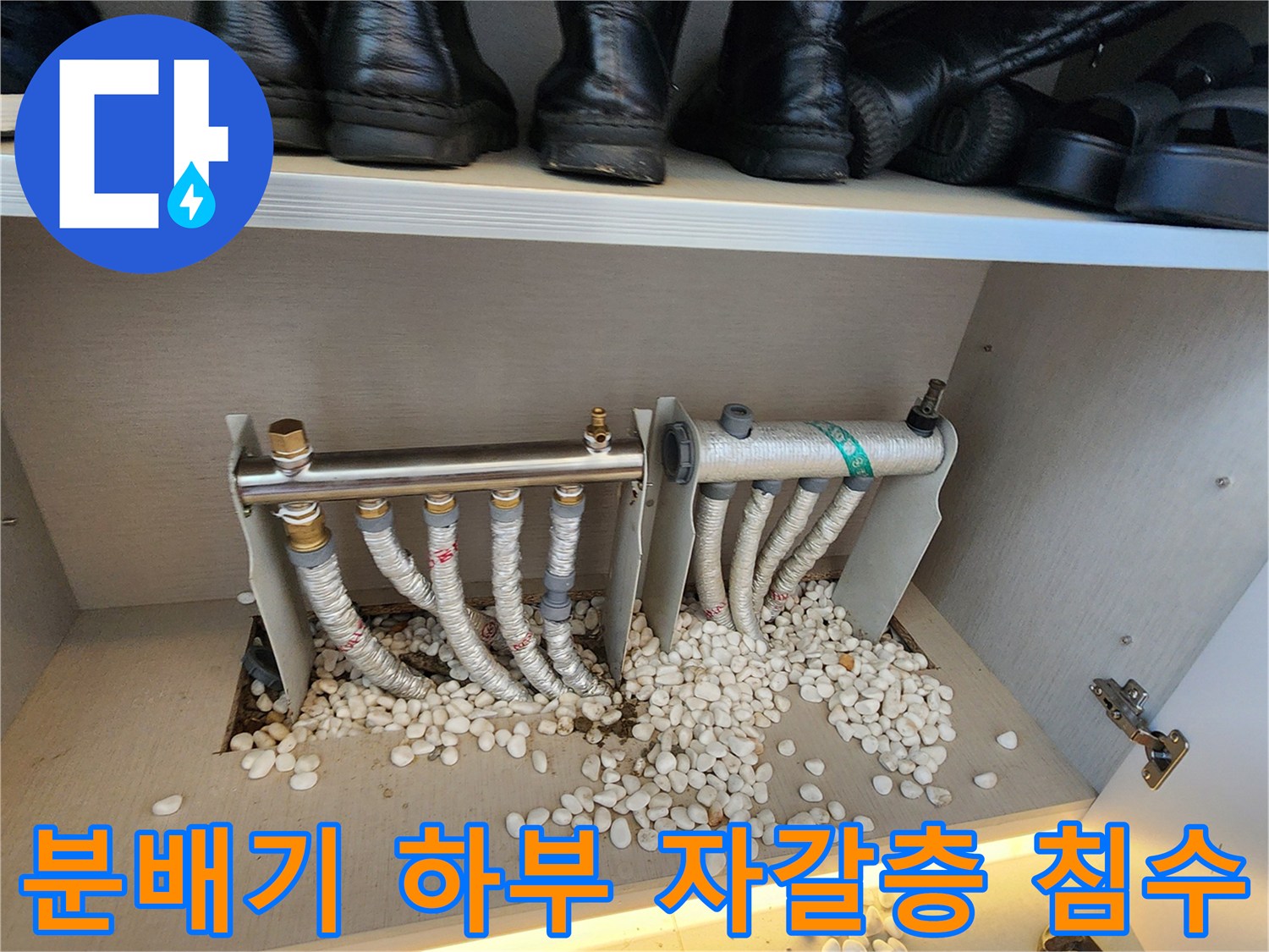 분배기 주변의 젖은 자갈과 배관 연결 상태를 보여주는 사진입니다.