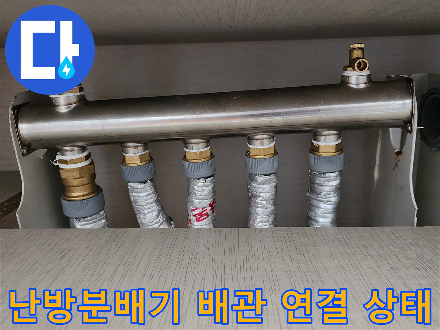 스테인리스 소재의 난방 분배기와 은색 보온재로 감싸진 연결 배관들