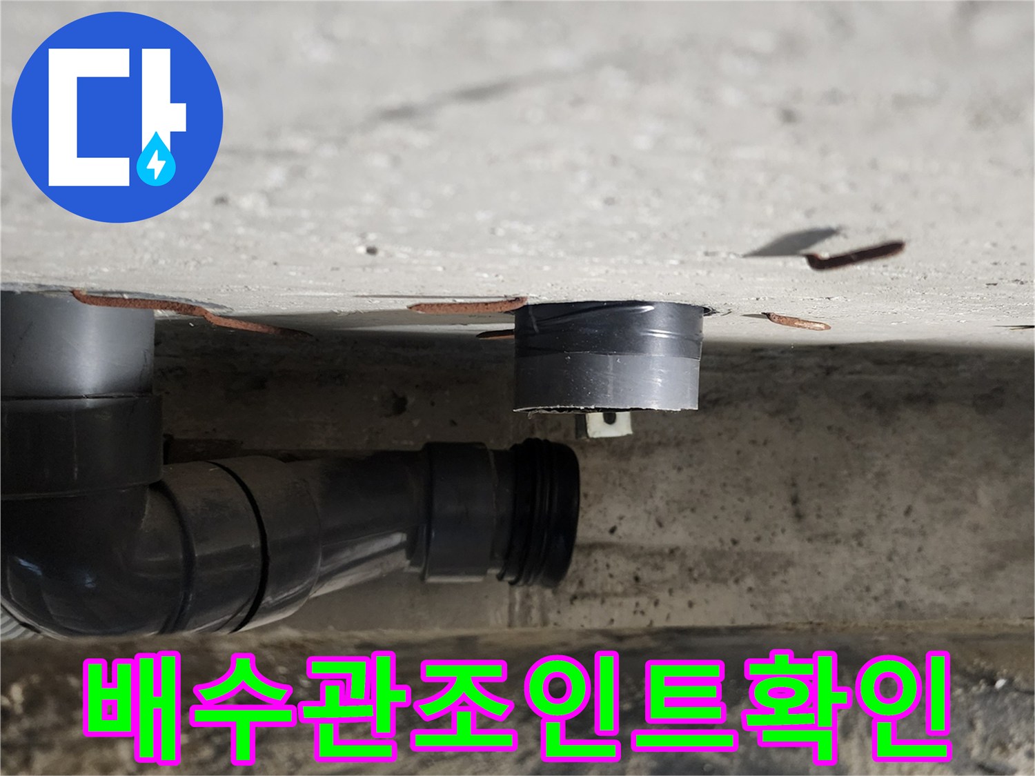 검은색 PVC 배관의 굴곡진 연결 부위와 천장 구조물