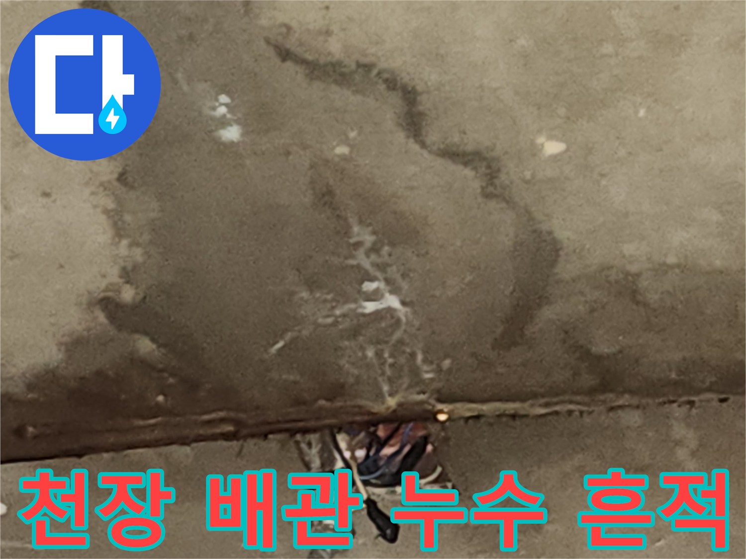 배관 연결부 근처의 짙은 습기 자국과 얼룩