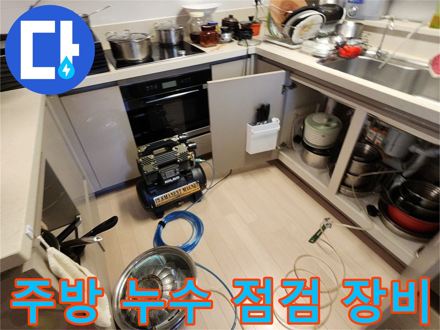 싱크대 하부장 아래 배치된 누수 탐지용 공기압 테스트 장비와 호스