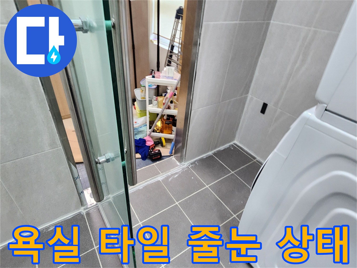 욕실 바닥의 타일 마감과 세탁기 주변 공간을 촬영한 사진입니다.