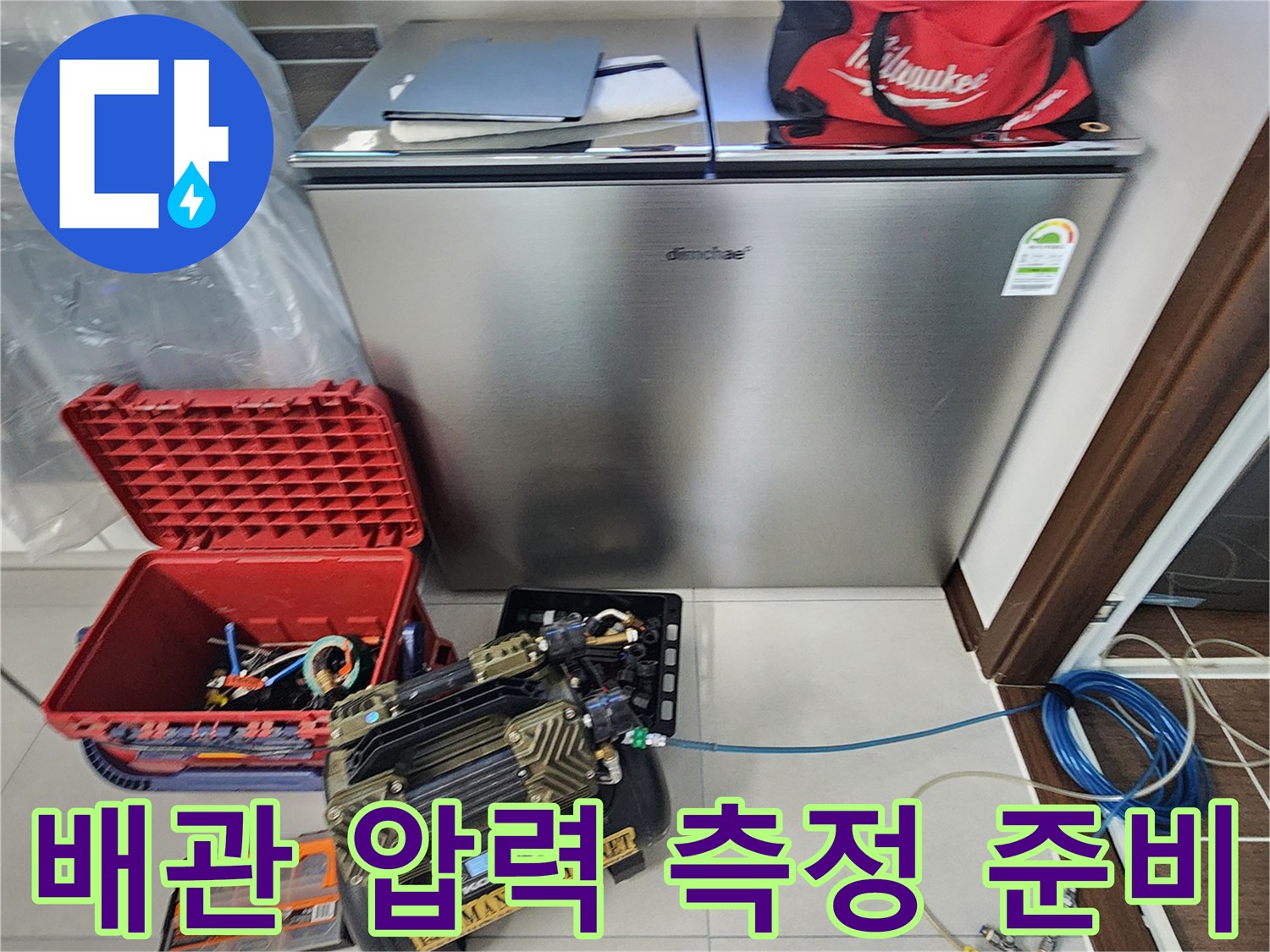 압력 게이지와 가스 탐지 호스를 연결하여 배관 점검을 준비하는 엔지니어의 모습