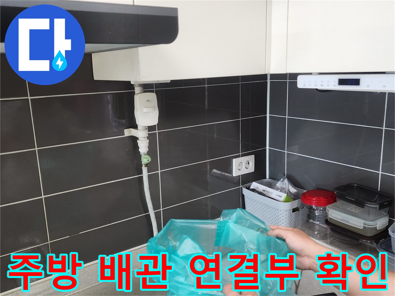 싱크대 하단 급수 밸브와 호스 부위의 누수 여부를 점검하는 모습입니다.