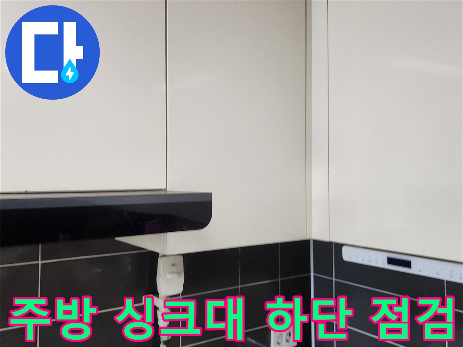 싱크대 하단 타일 벽면과 전기 콘센트 부위의 상세 촬영본