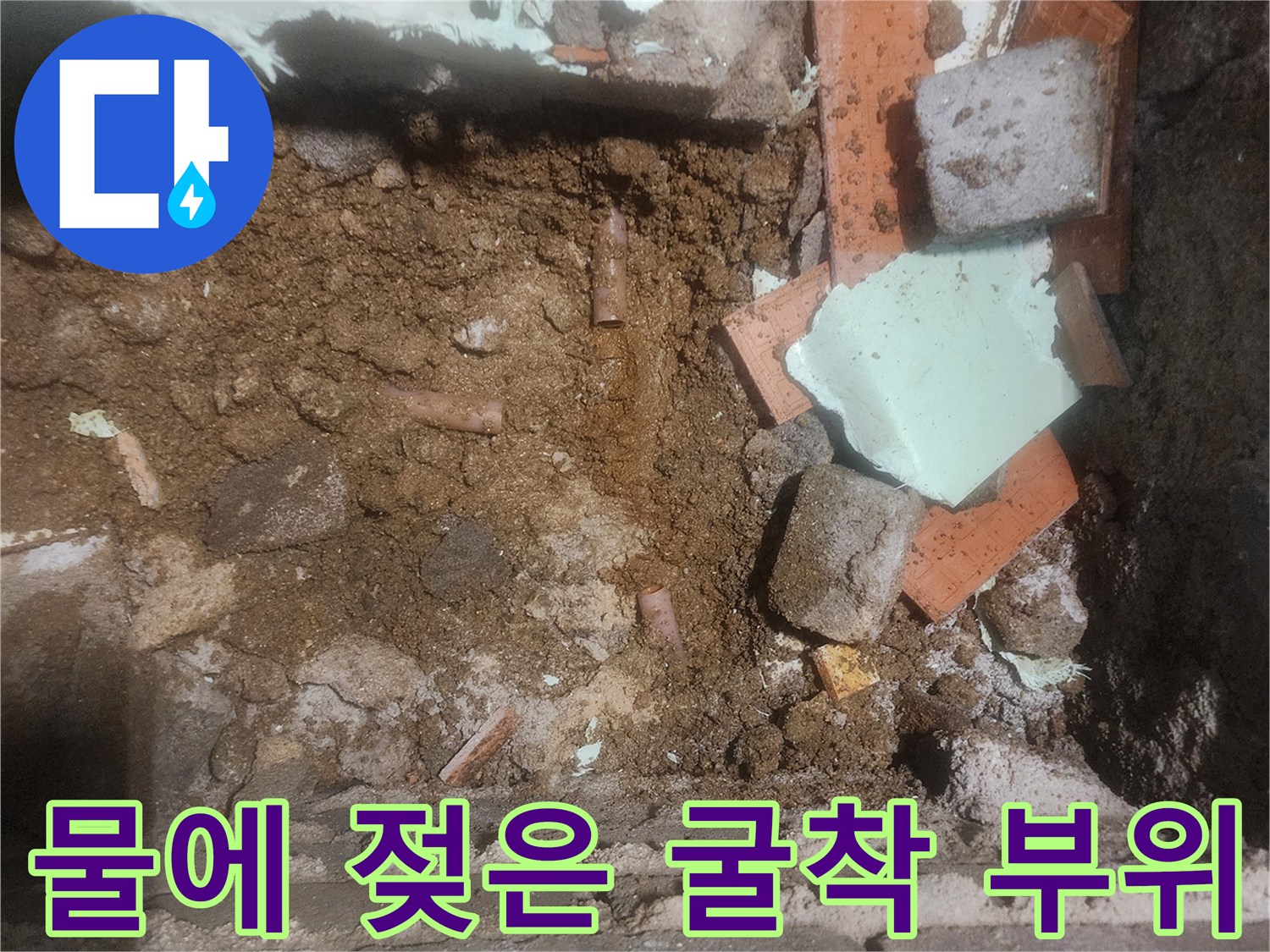 누수가 발생한-배관 주변의 젖은 흙과 파편