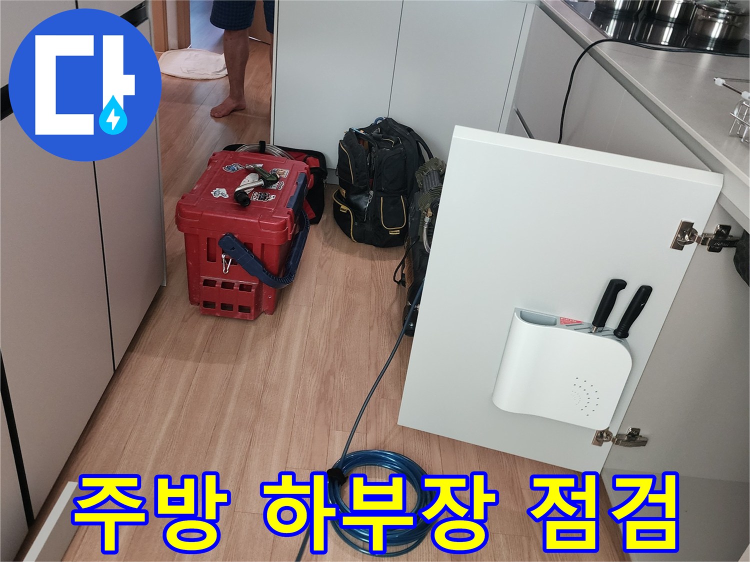 싱크대 아래쪽 공간에서 진행되는 배관 누수 정밀 탐지 상황입니다.