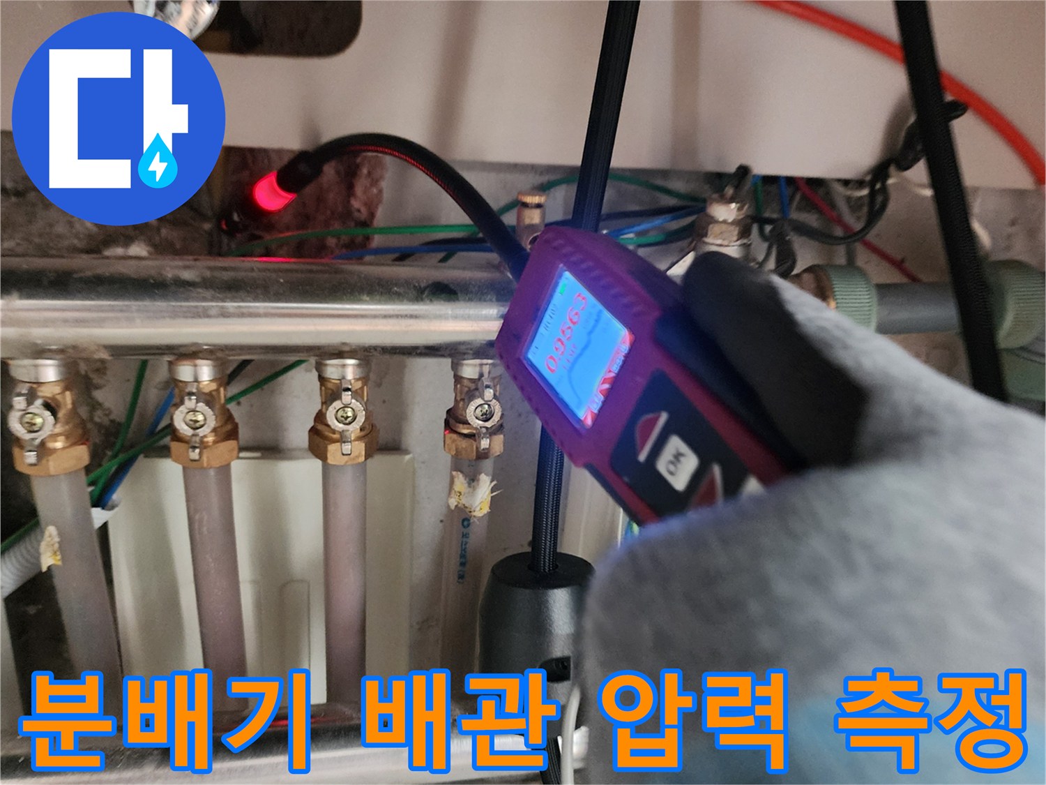 싱크대 하단 분배기 주변에서 가스 탐지기를 사용하여 배관 압력을 확인하는 모습입니다.