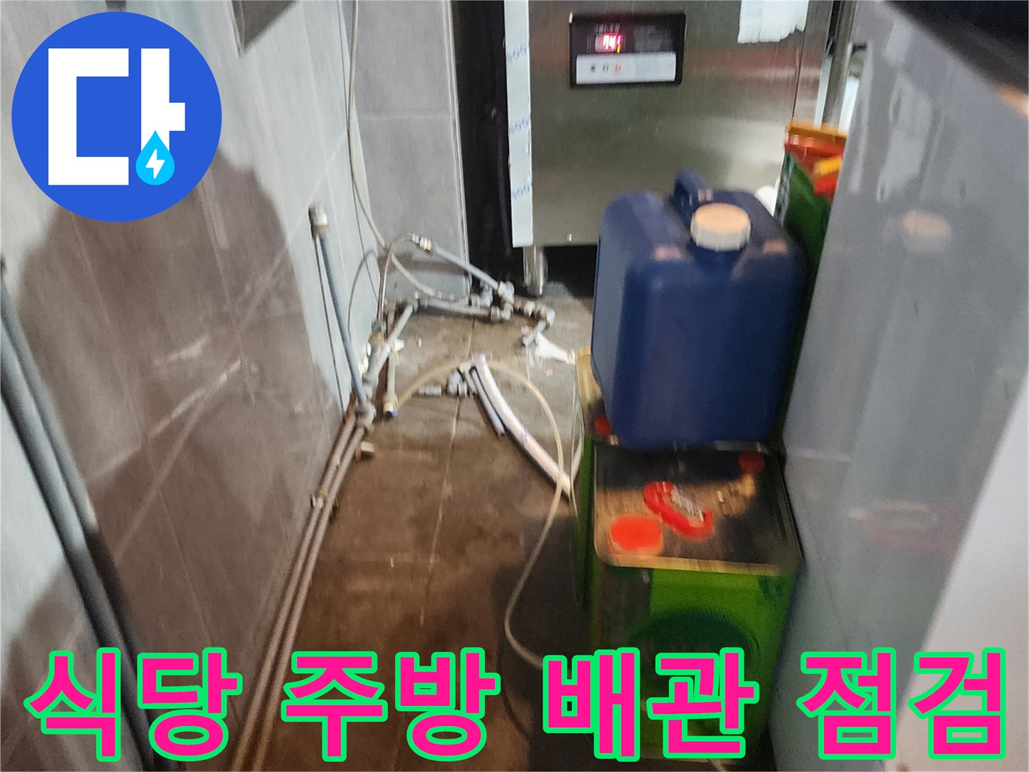 주방 기구 아래쪽의 복잡한 배관 연결 부위 상세 촬영
