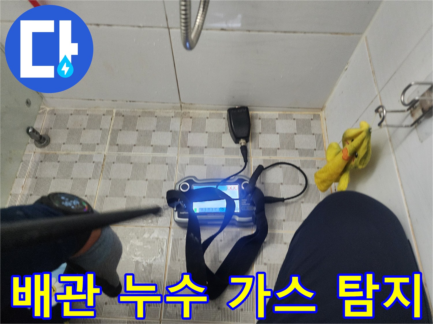 욕실 바닥 타일 위에서 진행 중인 배관 가스식 탐지 작업 현장