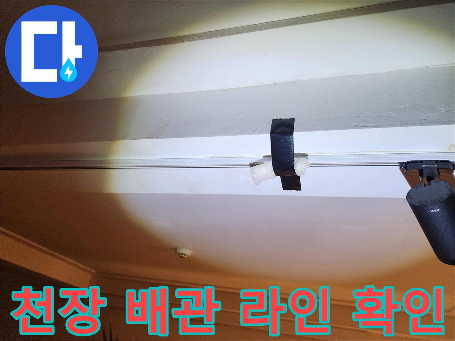 손전등으로 밝게 비춘 천장 배관 및 고정 부위