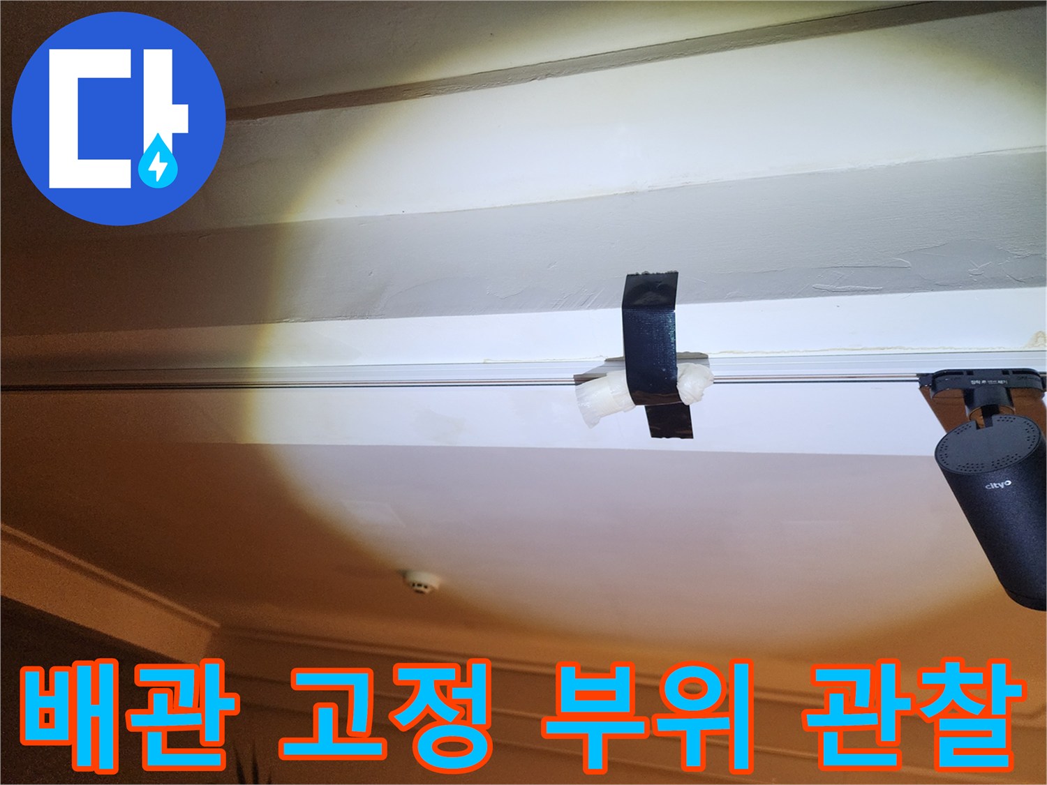 천장 구조물과 배관이 만나는 지점의 근접 사진